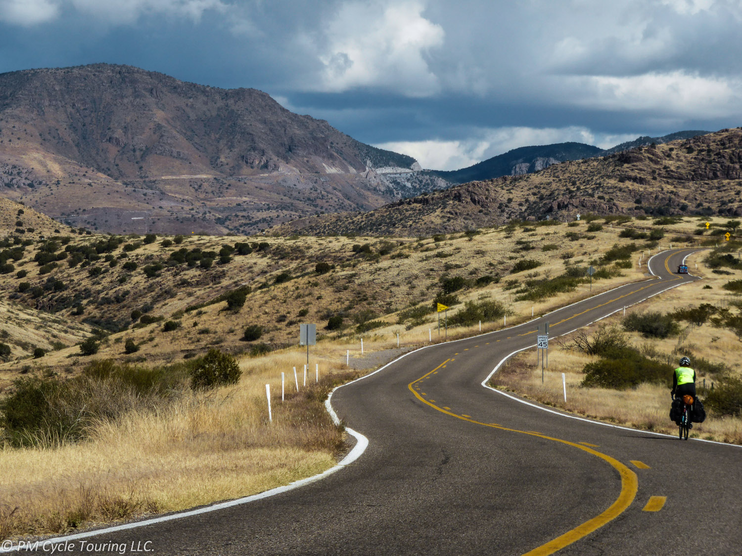 Bicyle tourist rides up a steep hill on AZ 78 in Arizona.