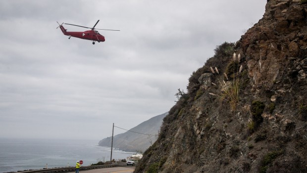 Helicopter over Pacific Coast Highway 1 near Lime Kiln, California. Major road construction was in progress and they were lifting workers from the road up the mountain.