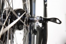 A close-up of stainless steel dropouts on a front wheel